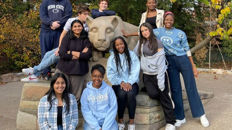 Ten students pose at Penn State's Nittany Lion shrine.